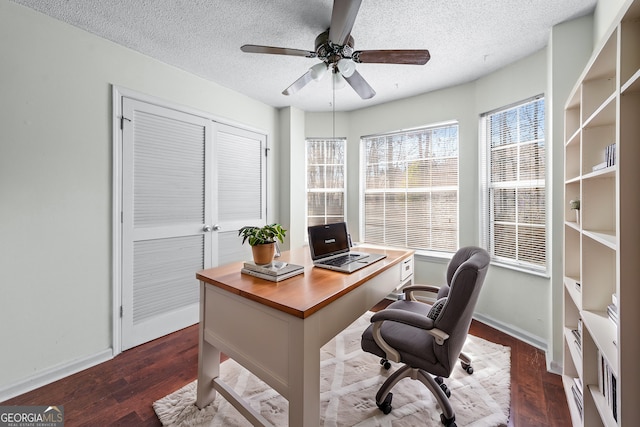 office featuring baseboards, a textured ceiling, dark wood-type flooring, and ceiling fan