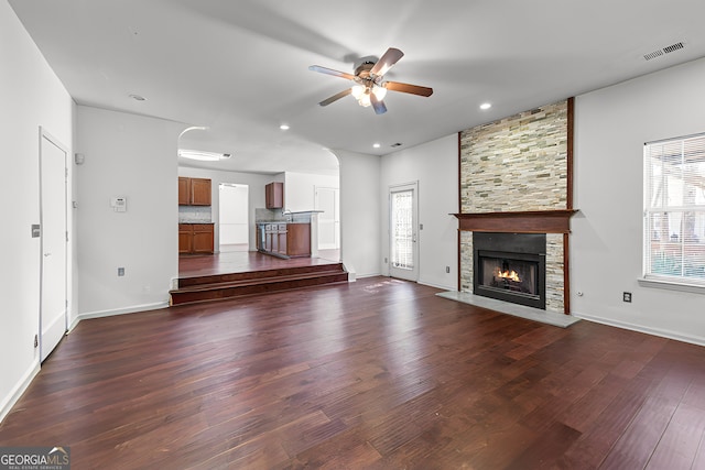 unfurnished living room with a ceiling fan, visible vents, recessed lighting, a fireplace, and dark wood-type flooring