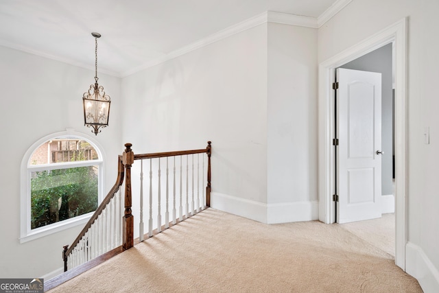 hall with crown molding, baseboards, a chandelier, an upstairs landing, and carpet flooring