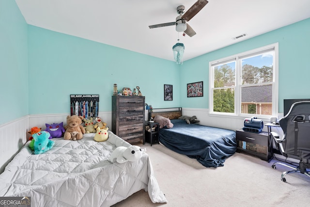 bedroom with visible vents, wainscoting, a ceiling fan, and carpet floors