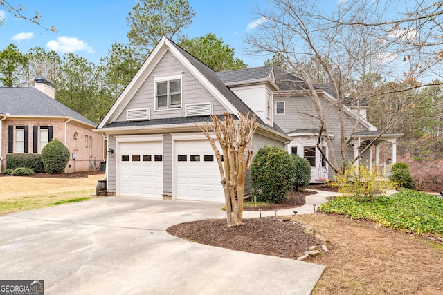 view of front facade with roof with shingles and driveway