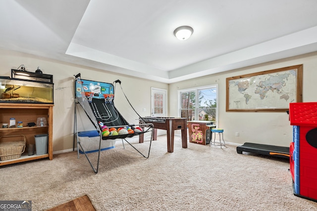 game room with a tray ceiling, carpet flooring, and baseboards