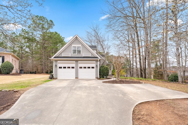 view of side of property featuring concrete driveway and a garage