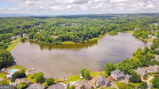 drone / aerial view featuring a forest view, a water view, and a residential view