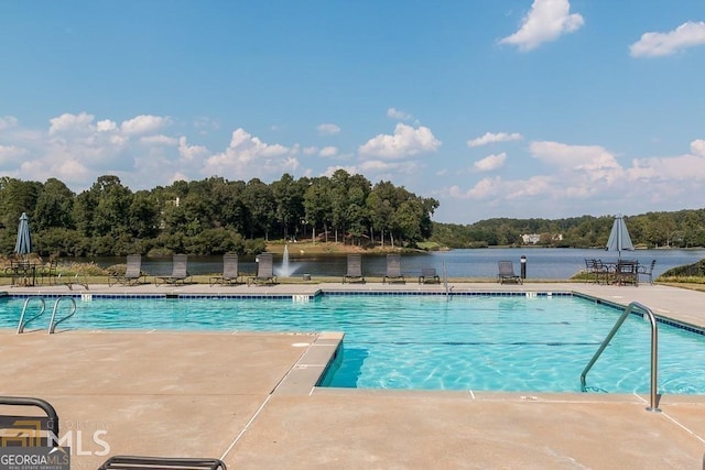 pool with a patio and a water view