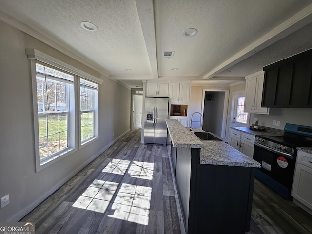 kitchen featuring visible vents, beam ceiling, dark wood-style flooring, a sink, and stainless steel appliances