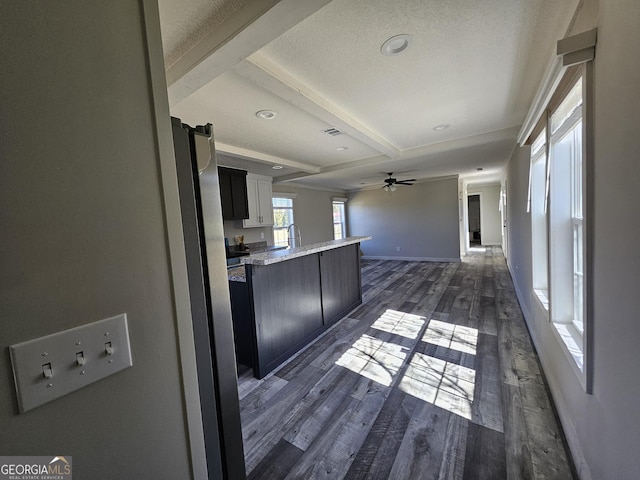 kitchen with visible vents, dark wood finished floors, open floor plan, beamed ceiling, and a peninsula