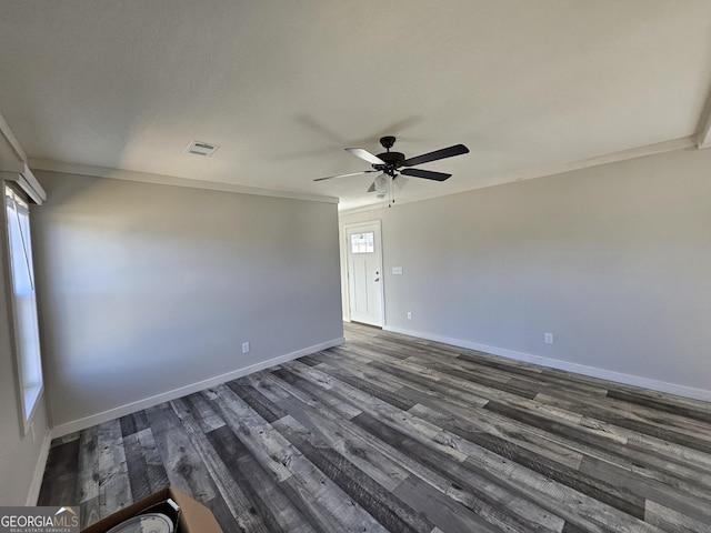 unfurnished room featuring visible vents, ornamental molding, a ceiling fan, baseboards, and dark wood-style flooring