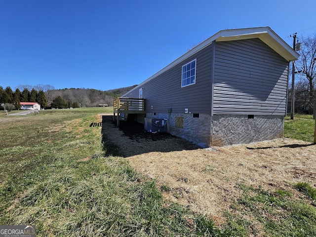 view of home's exterior with a lawn, central AC, and crawl space