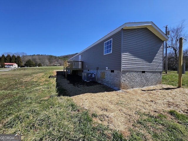 view of property exterior featuring crawl space, central AC unit, and a yard