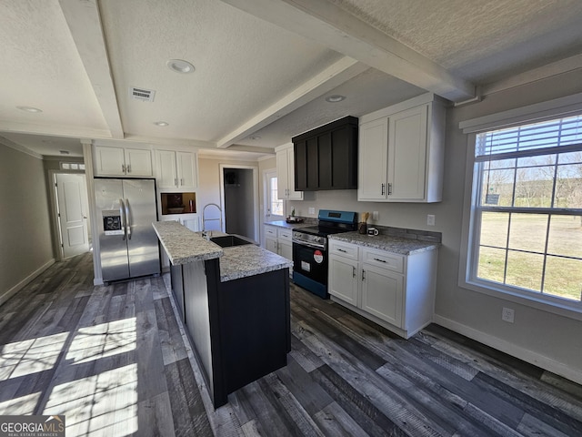 kitchen featuring visible vents, a sink, beamed ceiling, stainless steel appliances, and dark wood-style flooring