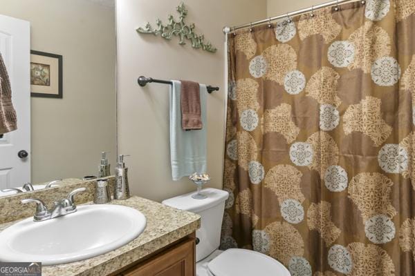 bathroom featuring curtained shower, toilet, and vanity