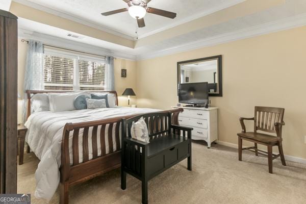 bedroom featuring visible vents, baseboards, light colored carpet, a tray ceiling, and ornamental molding