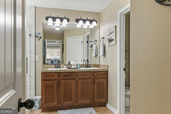 full bath featuring double vanity, toilet, and a sink