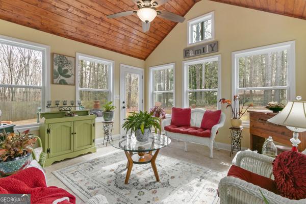 sunroom / solarium with wooden ceiling, a ceiling fan, and lofted ceiling