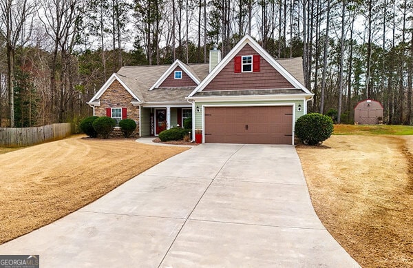 craftsman house featuring fence, a chimney, a front lawn, concrete driveway, and a garage