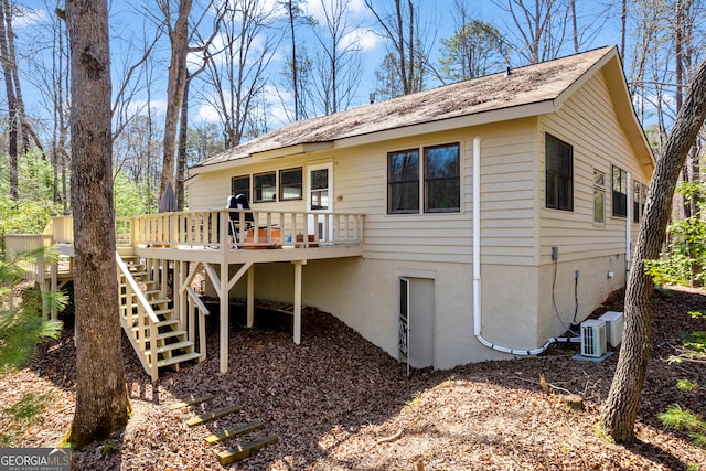 back of house featuring stairway and a wooden deck