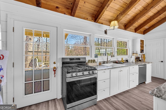 kitchen with a sink, wooden ceiling, vaulted ceiling with beams, and stainless steel appliances