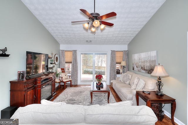 living area featuring a textured ceiling, a ceiling fan, lofted ceiling, and wood finished floors