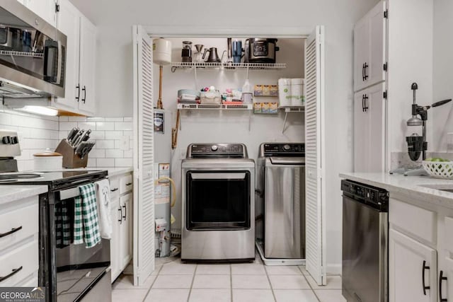 laundry area featuring light tile patterned floors, independent washer and dryer, and laundry area