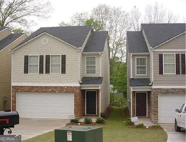 view of front of home with a garage, a front lawn, brick siding, and driveway