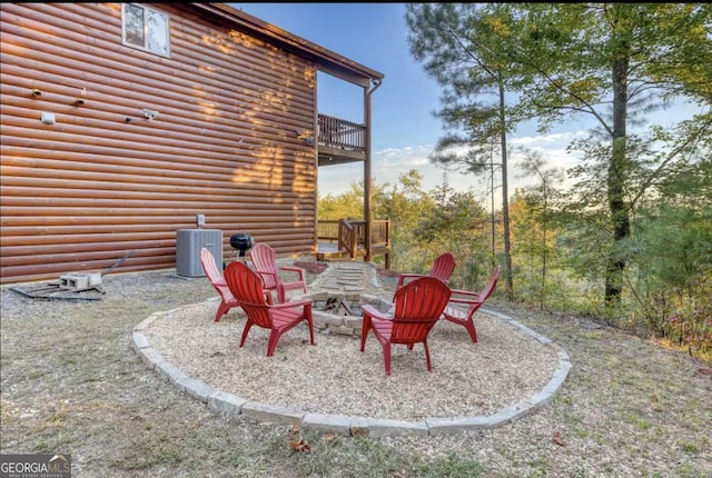 view of yard featuring central air condition unit and an outdoor fire pit