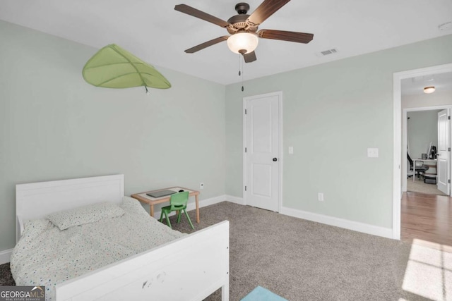 carpeted bedroom with visible vents, baseboards, and ceiling fan