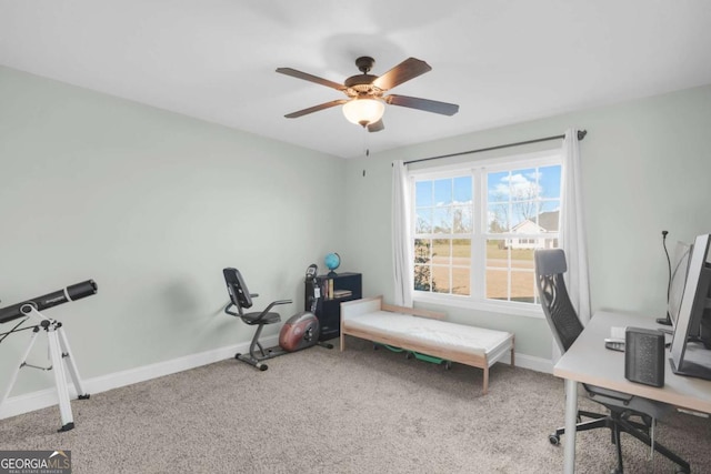 carpeted office with a ceiling fan and baseboards