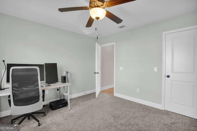 carpeted office with visible vents, baseboards, and ceiling fan