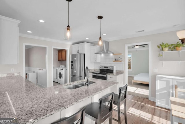 kitchen featuring visible vents, wall chimney range hood, washer and clothes dryer, stainless steel appliances, and open shelves