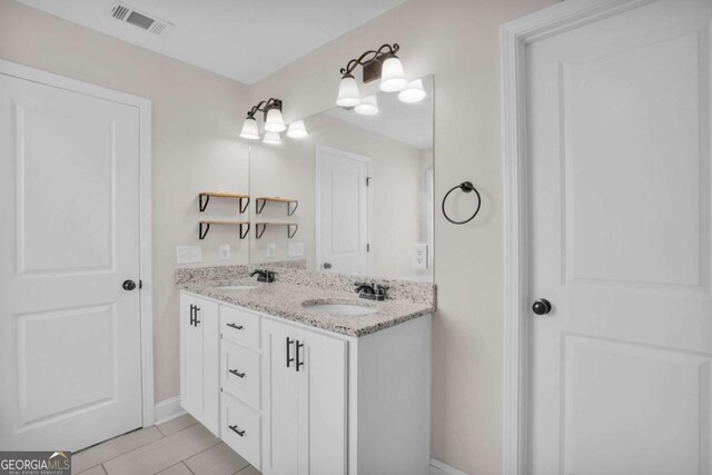 bathroom featuring double vanity, visible vents, baseboards, and a sink