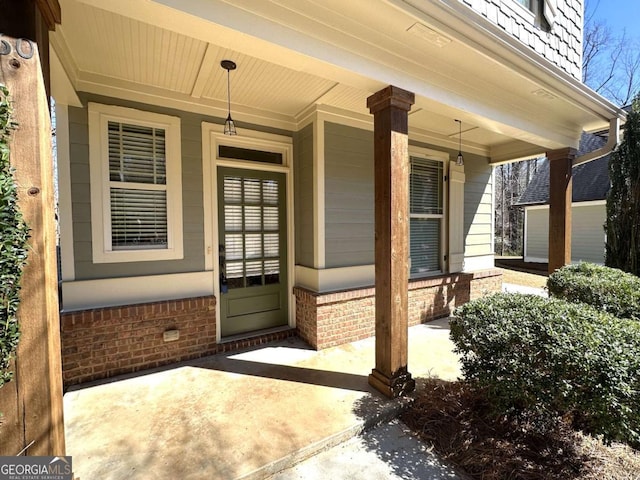 property entrance with brick siding and covered porch