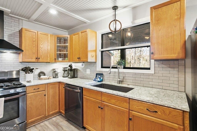 kitchen with a sink, light stone counters, wall chimney exhaust hood, dishwashing machine, and gas range