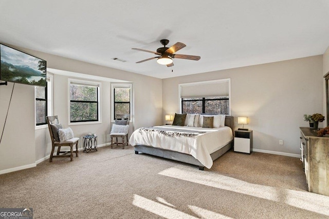 carpeted bedroom featuring visible vents, baseboards, and ceiling fan