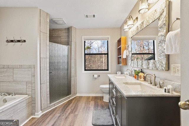 full bath with visible vents, a shower stall, toilet, and a sink