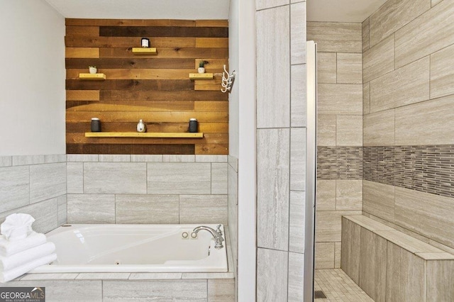 full bathroom featuring wooden walls, a tub with jets, and a tile shower