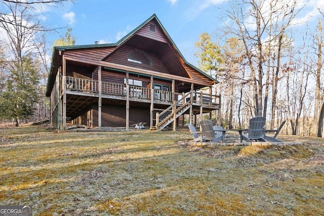 back of house with a wooden deck, a yard, stairs, and an outdoor fire pit