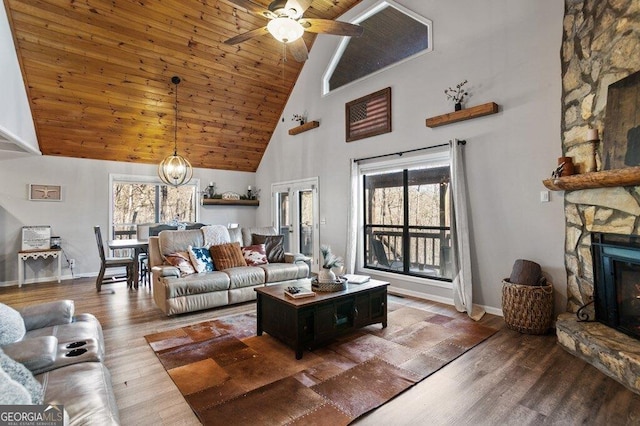 living room with baseboards, wood ceiling, wood finished floors, and a fireplace