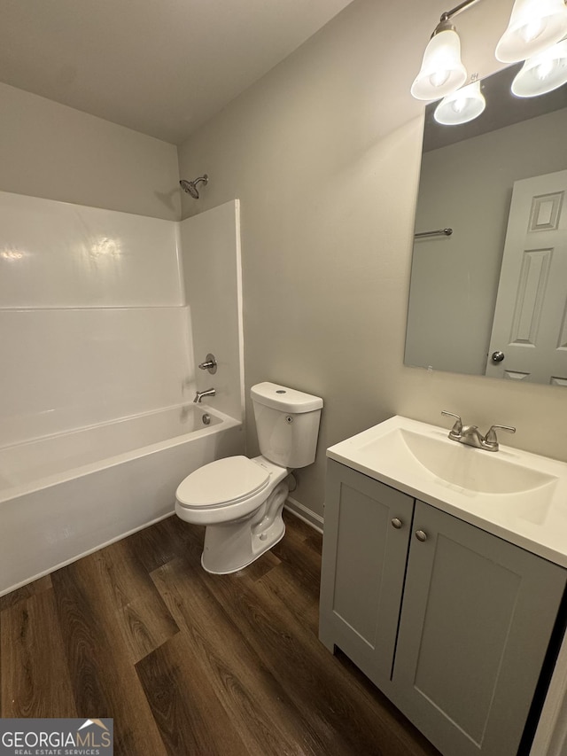 full bathroom with vanity, washtub / shower combination, toilet, and wood finished floors