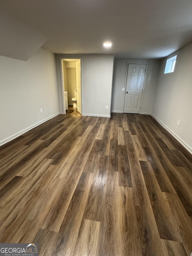 below grade area featuring dark wood-type flooring and baseboards