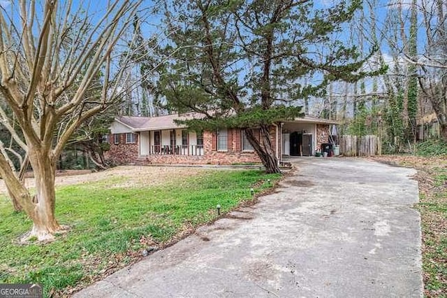 single story home featuring a front lawn, aphalt driveway, a porch, fence, and brick siding