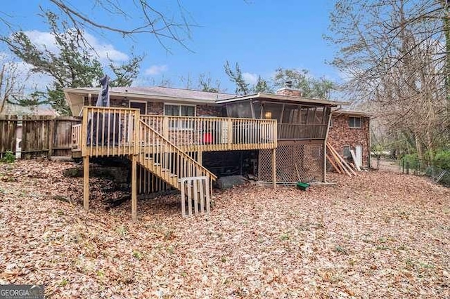 back of property with fence, stairway, a chimney, a deck, and a sunroom