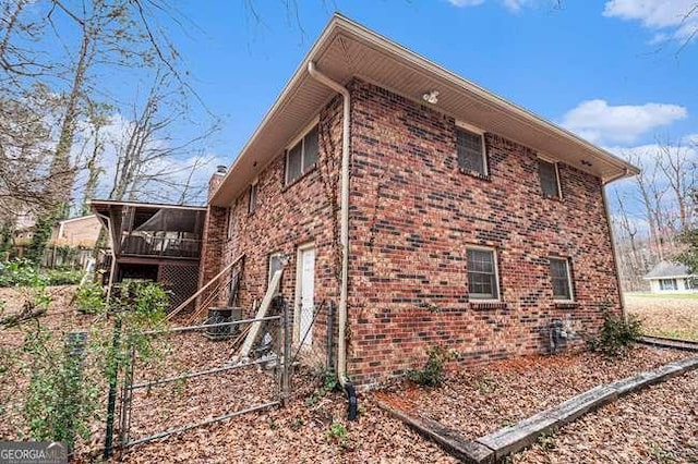 view of home's exterior with brick siding, stairs, and a garage