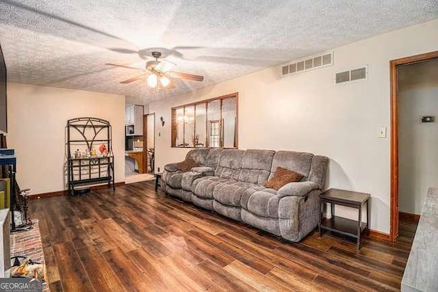 living room featuring a ceiling fan, wood finished floors, and visible vents