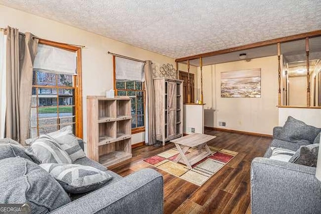 living room featuring a textured ceiling, baseboards, and wood finished floors