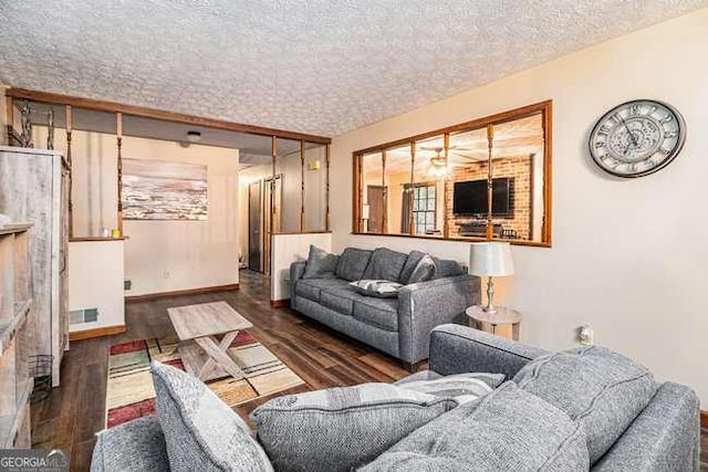 living room with baseboards, wood finished floors, visible vents, and a textured ceiling