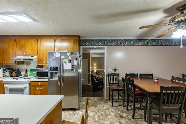 kitchen featuring under cabinet range hood, appliances with stainless steel finishes, and brown cabinetry