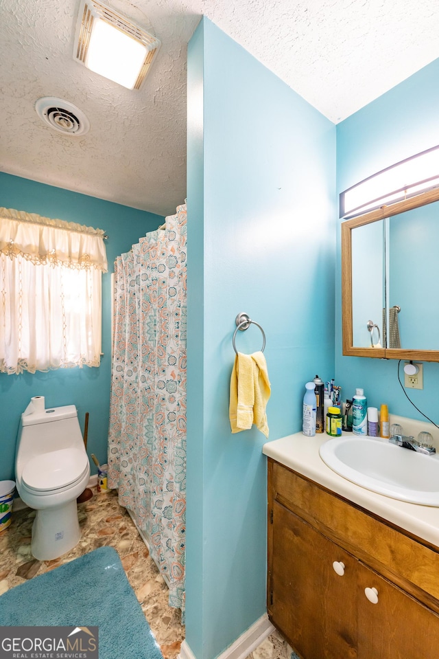 bathroom featuring vanity, a shower with shower curtain, visible vents, a textured ceiling, and toilet