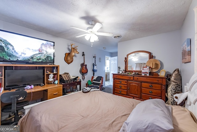 bedroom with connected bathroom, a ceiling fan, visible vents, and a textured ceiling