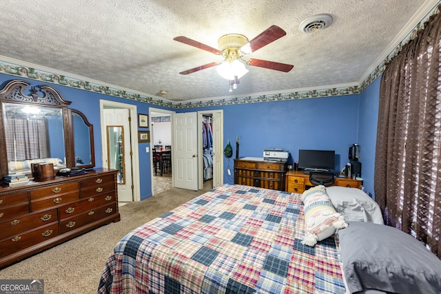 bedroom featuring ceiling fan, carpet, visible vents, and a textured ceiling